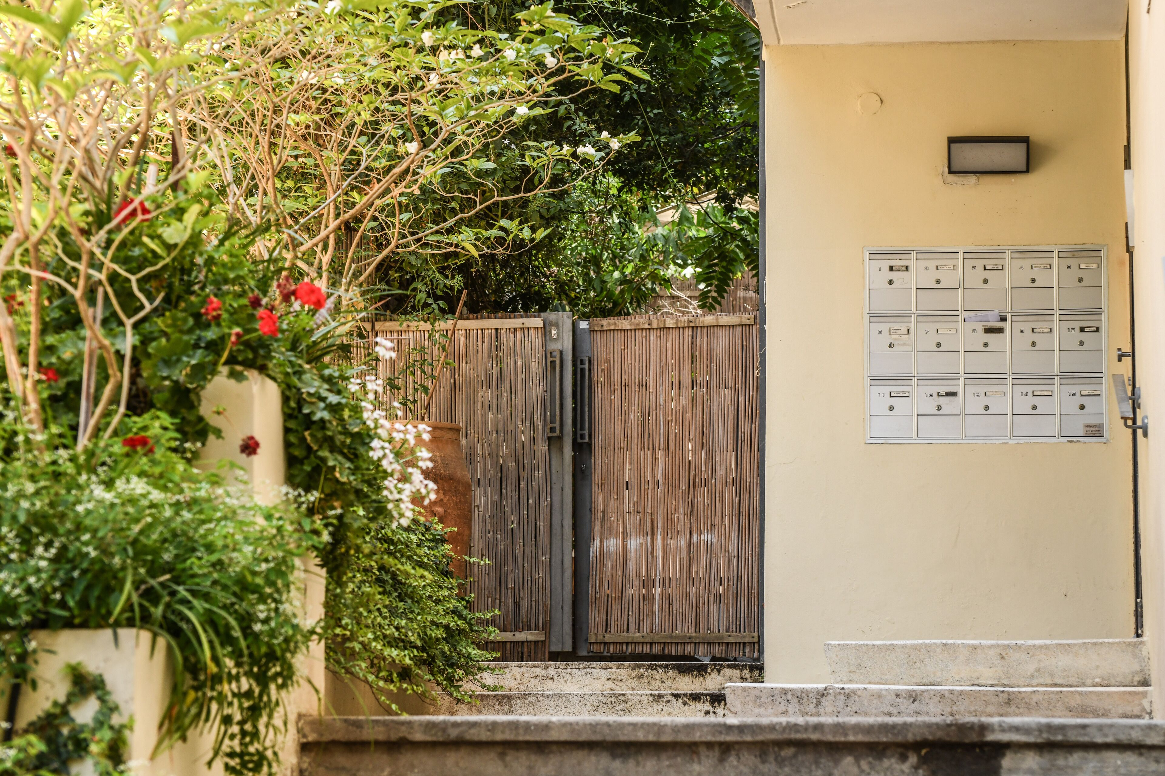A gated entrance with a mailbox and a wooden fence.