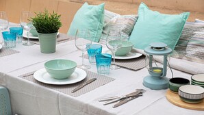 A table set with blue glassware, plates, and a green plant centerpiece. - Chalet Can Contestí (Llucmajor)