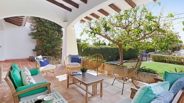 An outdoor patio with wooden furniture, a table, and a pergola structure. - Chalet Can Contestí (Llucmajor)