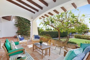 An outdoor patio with wooden furniture, a table, and a pergola structure. - Chalet Can Contestí (Llucmajor)