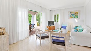 A living room with a TV, white furniture, a painting, and a view to the outside. - Chalet Can Contestí (Llucmajor)