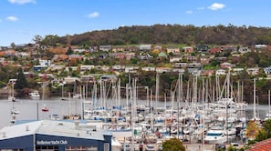 Un port de plaisance où sont amarrés de nombreux voiliers, entouré de bâtiments résidentiels situés sur une colline.