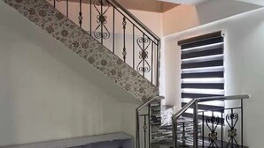 Una escala amb un mur amb motius florals i una barana de metall.
