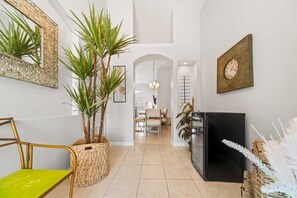 A modern interior with a dining area, a refrigerator, and decorative plants. - Private 4 BDR Oasis in Kissimmee with Pool | BBQ (Kissimmee)