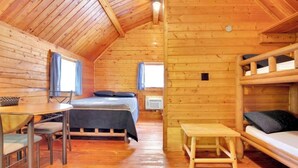 A cozy cabin with a wooden interior, a bunk bed, a dining area, and a small table. - Secluded Rustic Cabin with Views (Bloomington)