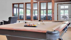 A pool table in a room with large windows and a wooden ceiling. - Stunning Aframe Cabin with Deck (Bloomington)