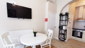 A compact kitchen with a white countertop, a black range hood, and a white door. - Lovely Renovated Large Spacious Georgian Studio (Dublin 1)