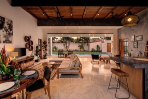 A spacious living area with a pool, wooden ceiling, and modern furniture. - Villa Maje by Alfred in Bali (Seminyak)