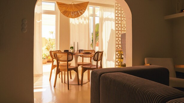 A dining area with a round table, four wooden chairs, and a woven ceiling light. - Vacation apartment Matimar, Costa Calma, terrace, WiFi (Costa Calma)