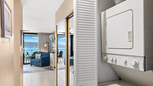 A hotel room with a balcony, a washing machine, and a view of the sea. - 1bd Oceanfront gem with charm, views & Island vibe (Lahaina)
