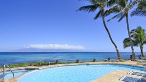 A pool area with a view of the ocean and palm trees. - 1bd Oceanfront gem with charm, views & Island vibe (Lahaina)