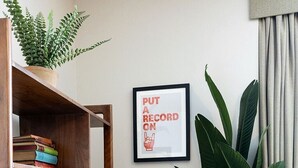 Ein Zimmer mit einer Holzhülle, einem gerahmten Poster und einer großen Topfpflanze.