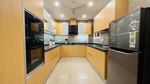 Una cocina moderna con armarios de madera, un refrigerador negro y un horno empotrado.