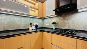 Una cocina moderna con armarios de madera, encimera negra y estufa a gas.