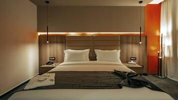 Una habitación de hotel moderna con una cama grande, dos mesitas de noche y una lámpara de pie.