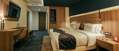 Una habitación de hotel moderna con una cama grande, un escritorio y una televisión.