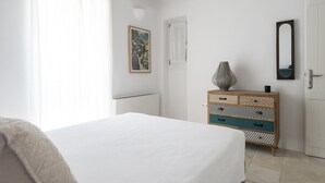 Un dormitorio con cama, cómoda, espejo y puerta.
