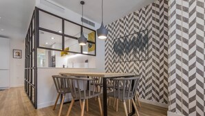 A modern kitchen with a central island, pendant lighting, and a herringbone-patterned wall. - Design apartment next to La Maestranza & Cathedral (Sevilla)