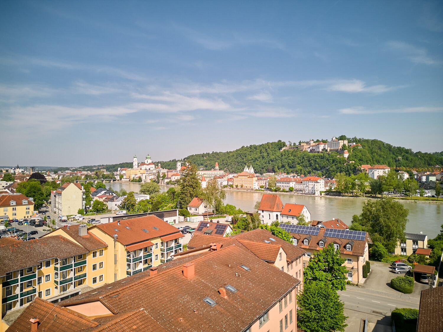 Une vue urbaine avec des bâtiments, une rivière et une colline en arrière-plan.