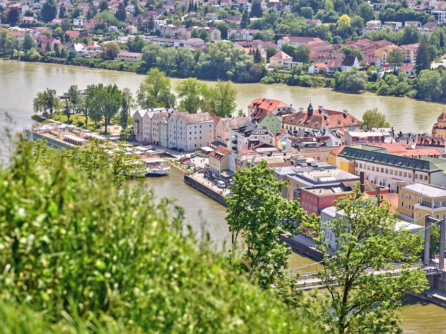 A riverside town with historic buildings, a bridge, and a boat dock.