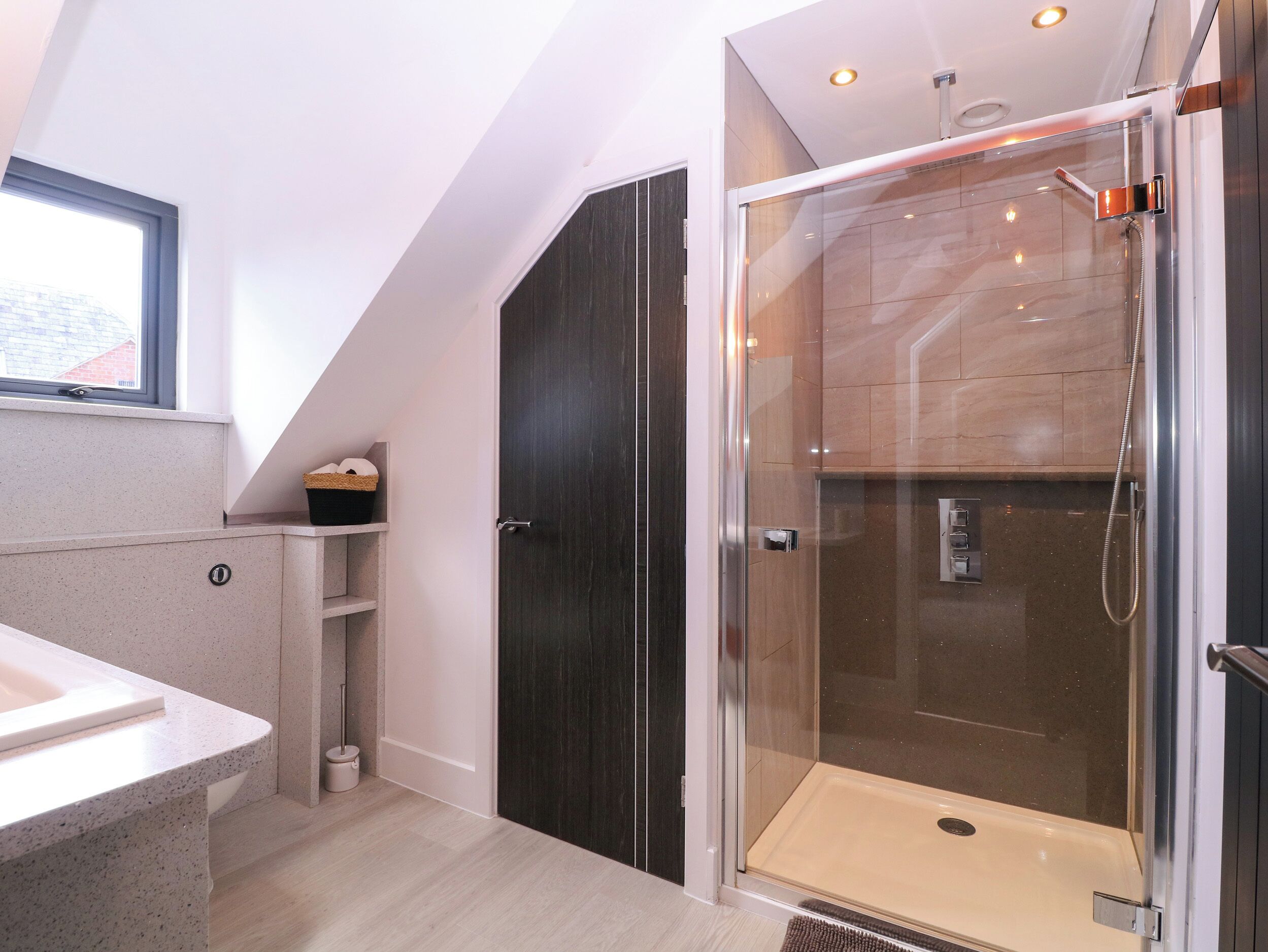 A modern bathroom with a shower, a vanity, and a window.