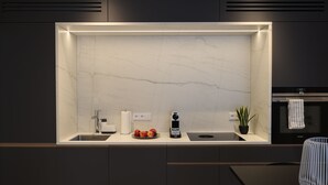Une cuisine moderne avec un dosseret en marbre, des appareils en acier inoxydable et un design minimaliste.