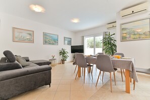 Relax in this stylish living and dining area with a sofa, dining table, and flat-screen TV.