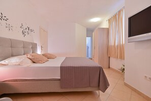 Relax in a spacious bedroom with a large bed and flat-screen TV.