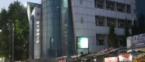 A multi-story building with a modern architectural design, featuring a prominent glass facade and a sign that reads "RADIN".
