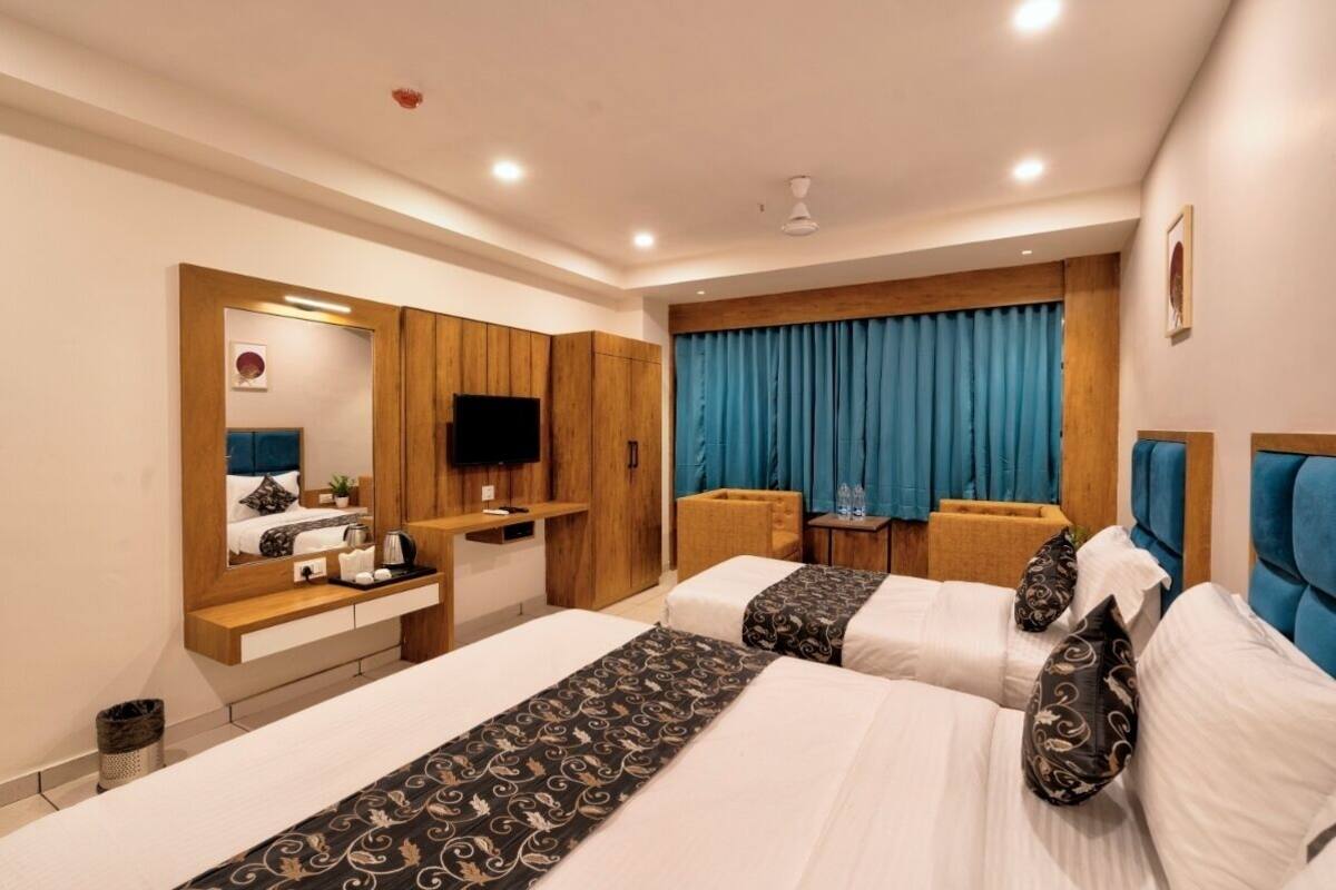 Une chambre d’hôtel avec deux lits, un bureau, une télévision et une salle de bain.