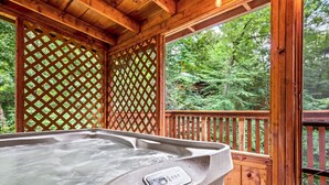 A hot tub in a wooden deck with a view of a forest. - Peaceful 3BR GBurg w/Hot Tub + Fireplace* Privacy! (Sevierville)