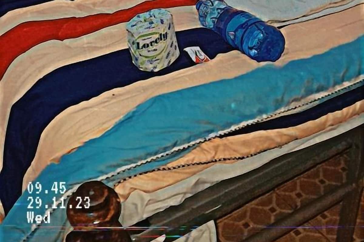 A bed with a metal frame, white pillows, and striped bedding.