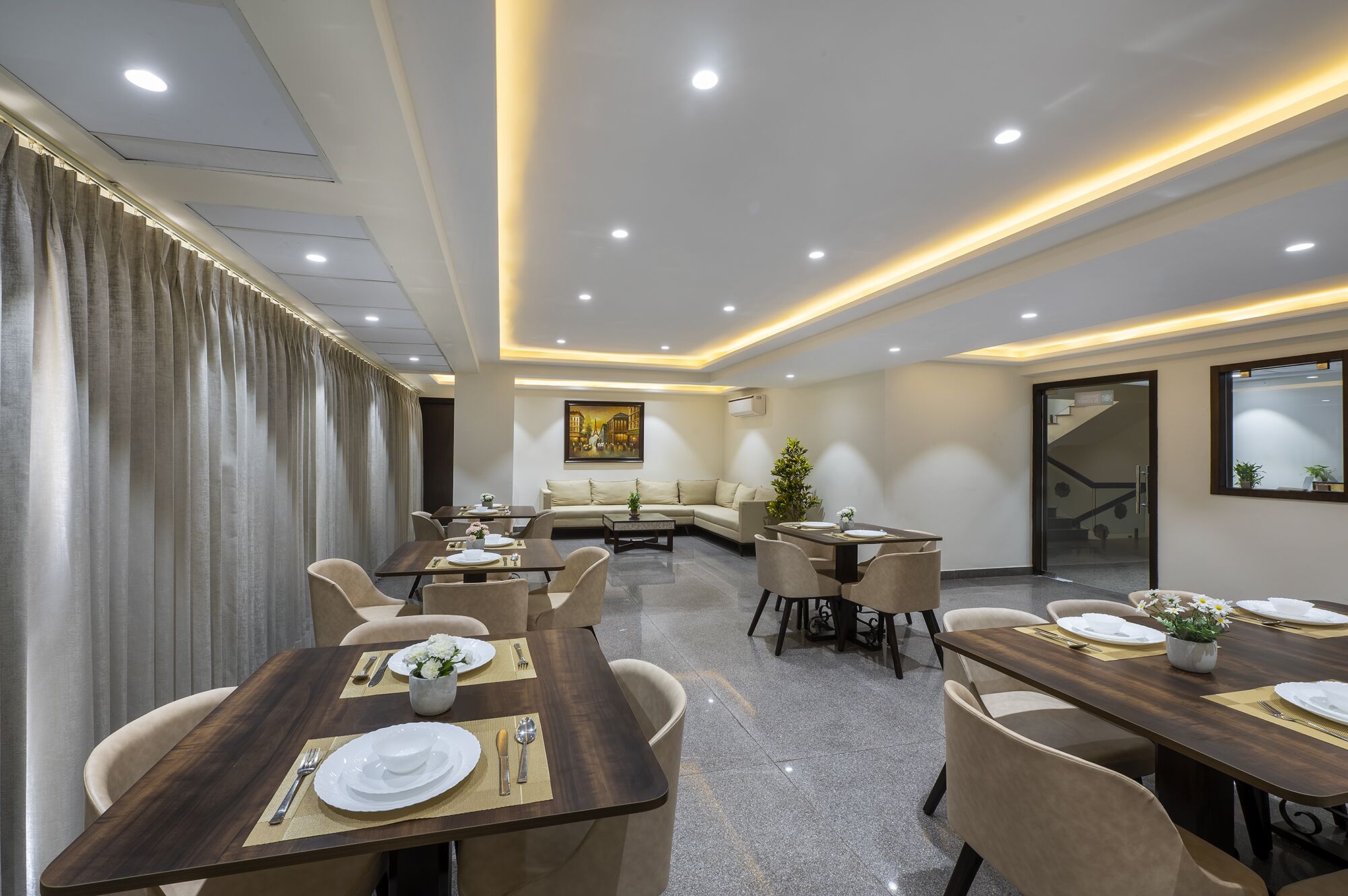 A modern conference room with a long table set for a meeting, a sofa, and a coffee table.