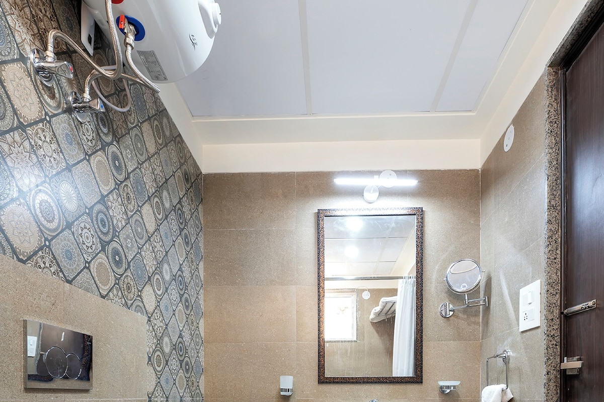 Un baño con lavamanos blanco, un espejo, inodoro y zona de ducha.