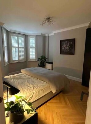 Cozy retreat with a single bed, window, and framed artwork.