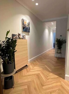 Enter a serene space with a herringbone-patterned floor, a desk, and framed artwork.