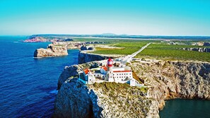 A coastal cliffside hotel with a lighthouse, offering panoramic views of the sea and distant landscapes. - Apartment Júlio Pomar (Sagres)