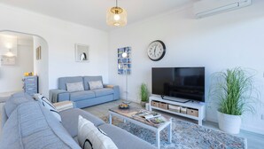 Ein modernes Wohnzimmer mit Sofa, Fernseher und Dekorationselementen.