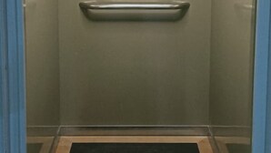 An elevator with a handrail, a light fixture, and a dark floor mat. - Pondy Heights - Suites and Studios (Puducherry)