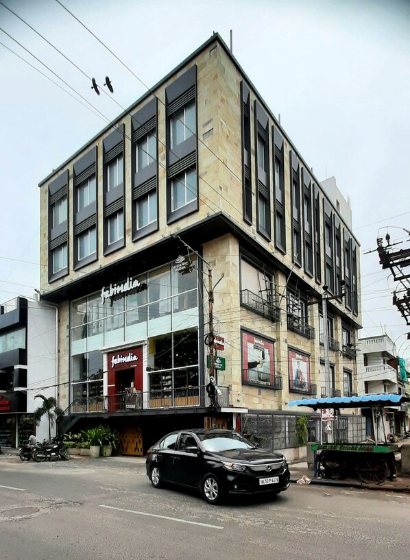 Un immeuble à étages, doté de grandes fenêtres et d’une devanture avec une enseigne indiquant « Fabindia ».