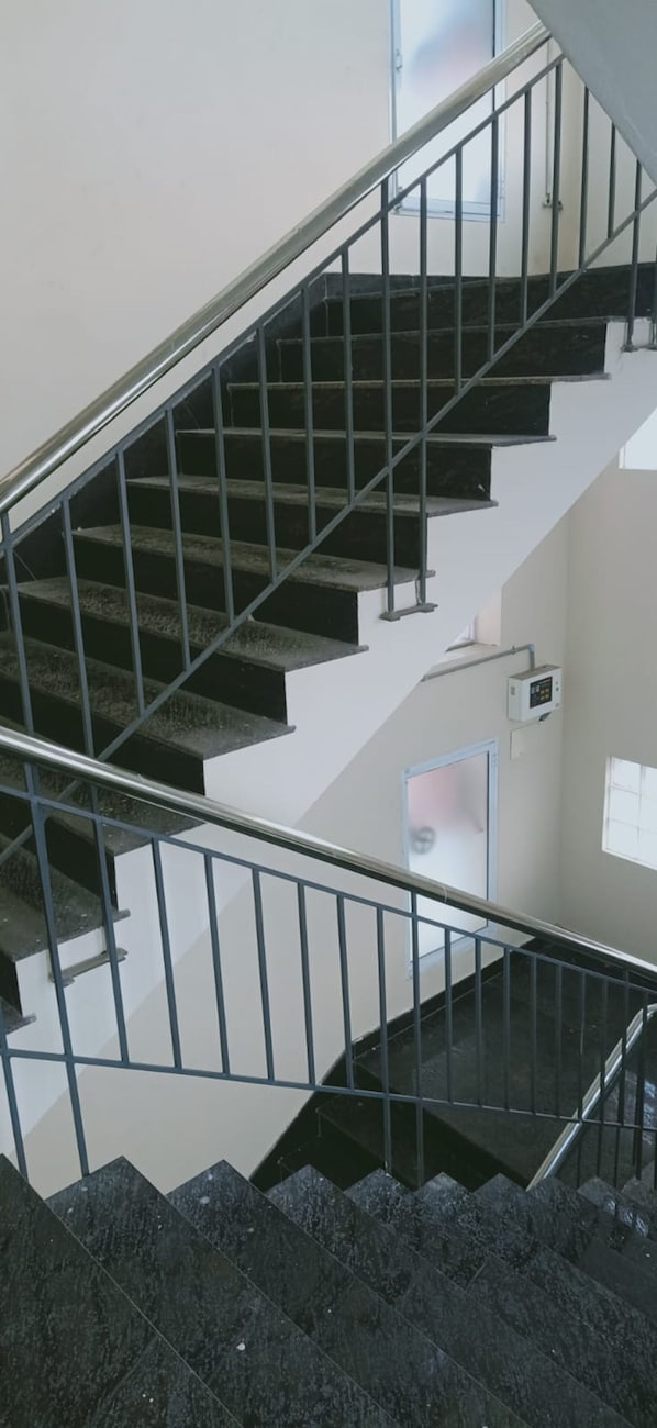 A staircase with metal railings and dark steps.