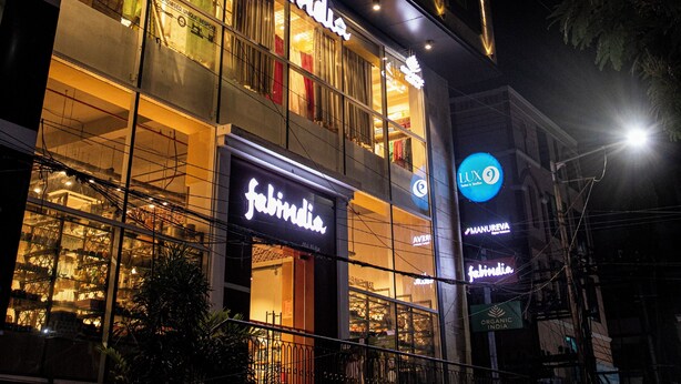A building with a storefront named 'Fabindia' at night. - Pondy Heights - Suites and Studios (Puducherry)