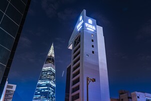 A modern hotel building with a prominent sign reading "TURA HOTEL".