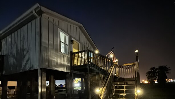 A two-story building with a wooden staircase leading to a balcony. - Relax & Unwind in a Serene Retreat Near the Beach (Port Arthur)