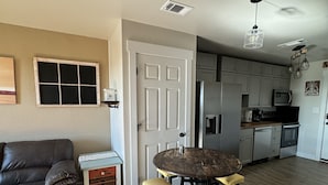 A compact living space with a dining area, kitchenette, and a sofa. - Relax & Unwind in a Serene Retreat Near the Beach (Port Arthur)