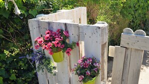 A wooden fence with two green flower pots attached to it. - La Rotta by Solturelba (Capoliveri)