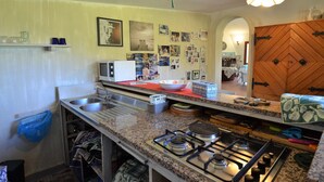 A kitchen with granite countertops, a gas stove, a microwave, and various kitchen items. - La Rotta by Solturelba (Capoliveri)