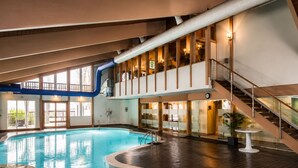 An indoor swimming pool with a wooden deck, a staircase, and a glass balustrade. - Family-Friendly Cozy Cabin Hot Tub, Fire Pit, Outdoor Pool & Ping Pong table (Clifton township)