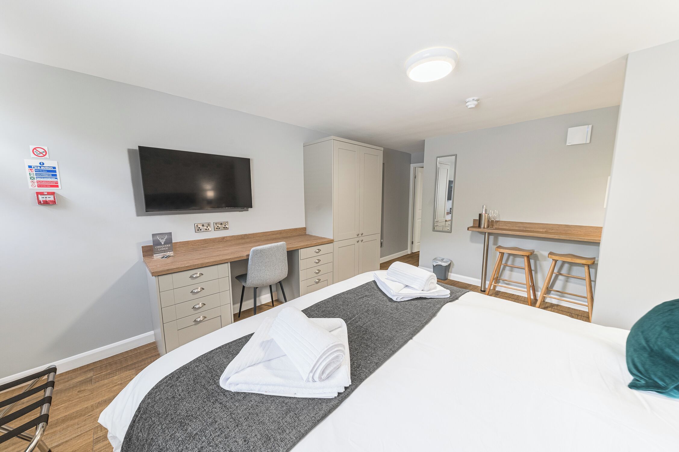 Une chambre d’hôtel équipée d’un lit, d’un bureau, d’une chaise, d’une télévision et d’une armoire.