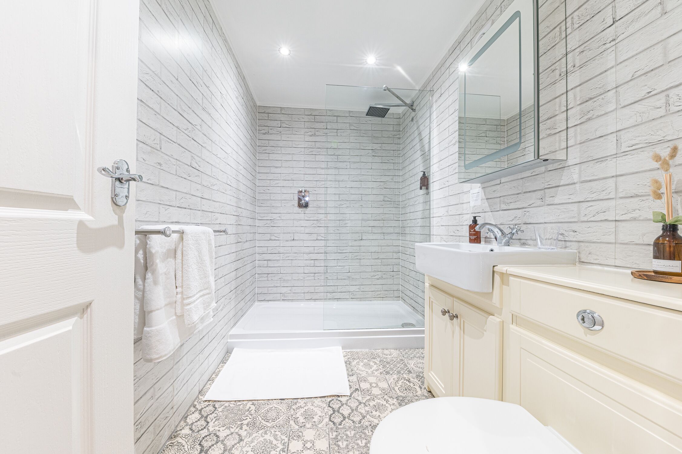 A modern bathroom with a shower, toilet, and vanity.